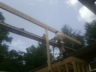 Carpenter setting a ridge beam over a new addition frame — Ice Dam Removal by Roofing Brothers in Presto